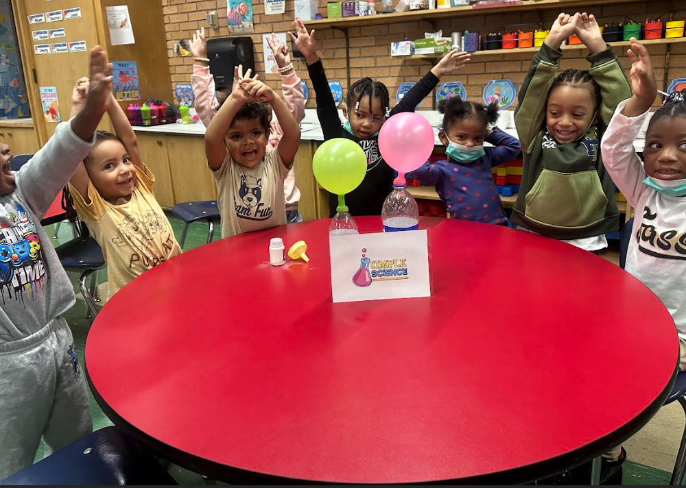 Teacher helping children create art in a classroom
